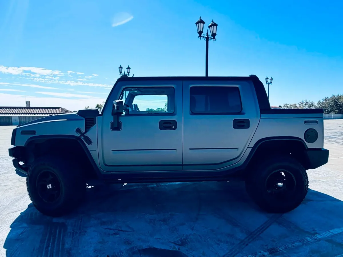 Hummer H2 negro con plata visto de lado, completo
